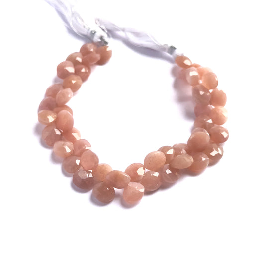 Peach Moonstone faceted briolette beads in soft peach tones, arranged in a sparkling 48-piece strand.