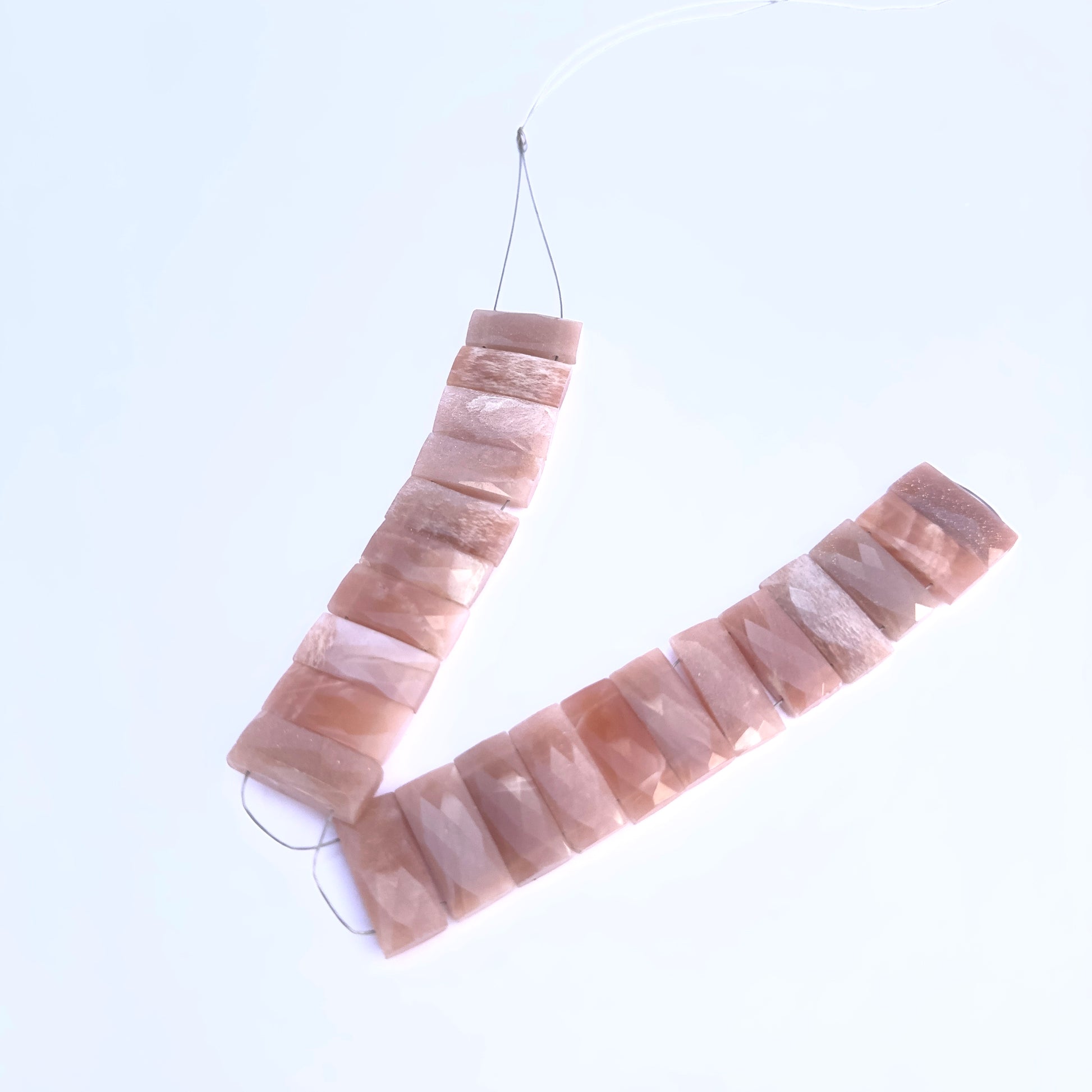 Peach Moonstone gemstone beads laid flat to highlight their rectangular shape and sparkle.