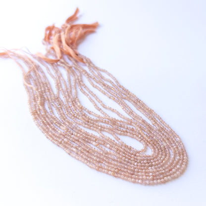 Handmade jewellery components featuring natural Peach Moonstone faceted rondelles, highlighting their glow, colour, and refined finish.