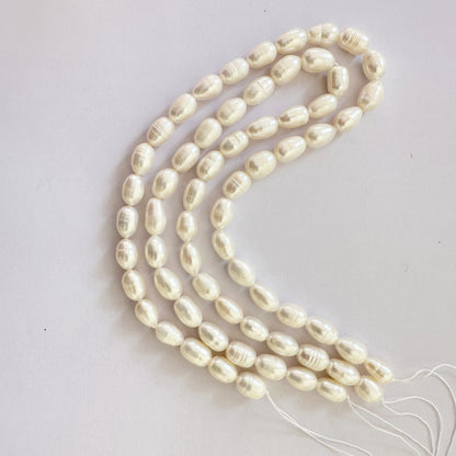 Textured pearl beads in oval shape reflect gentle sheen with organic charm.