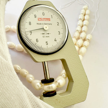 A dial gauge measures the pearl oval textured gemstone.