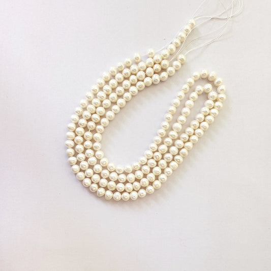Natural pearl round beads with lustrous ivory tones and smooth 5.4–5.6mm surface.