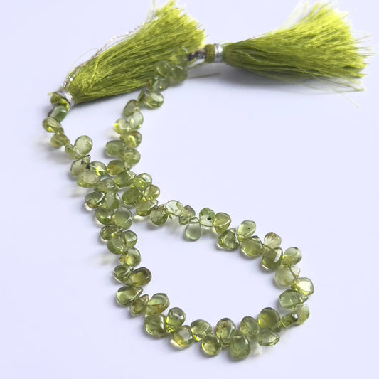 Stone beads in a strand of Peridot, highlighting their smooth drops and 4–5mm size.