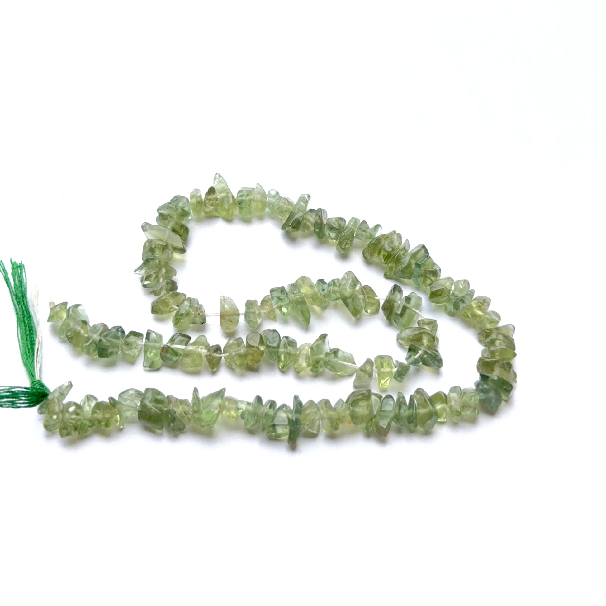 A person holds delicate strands of Labradorite beads, showcasing their smooth design.