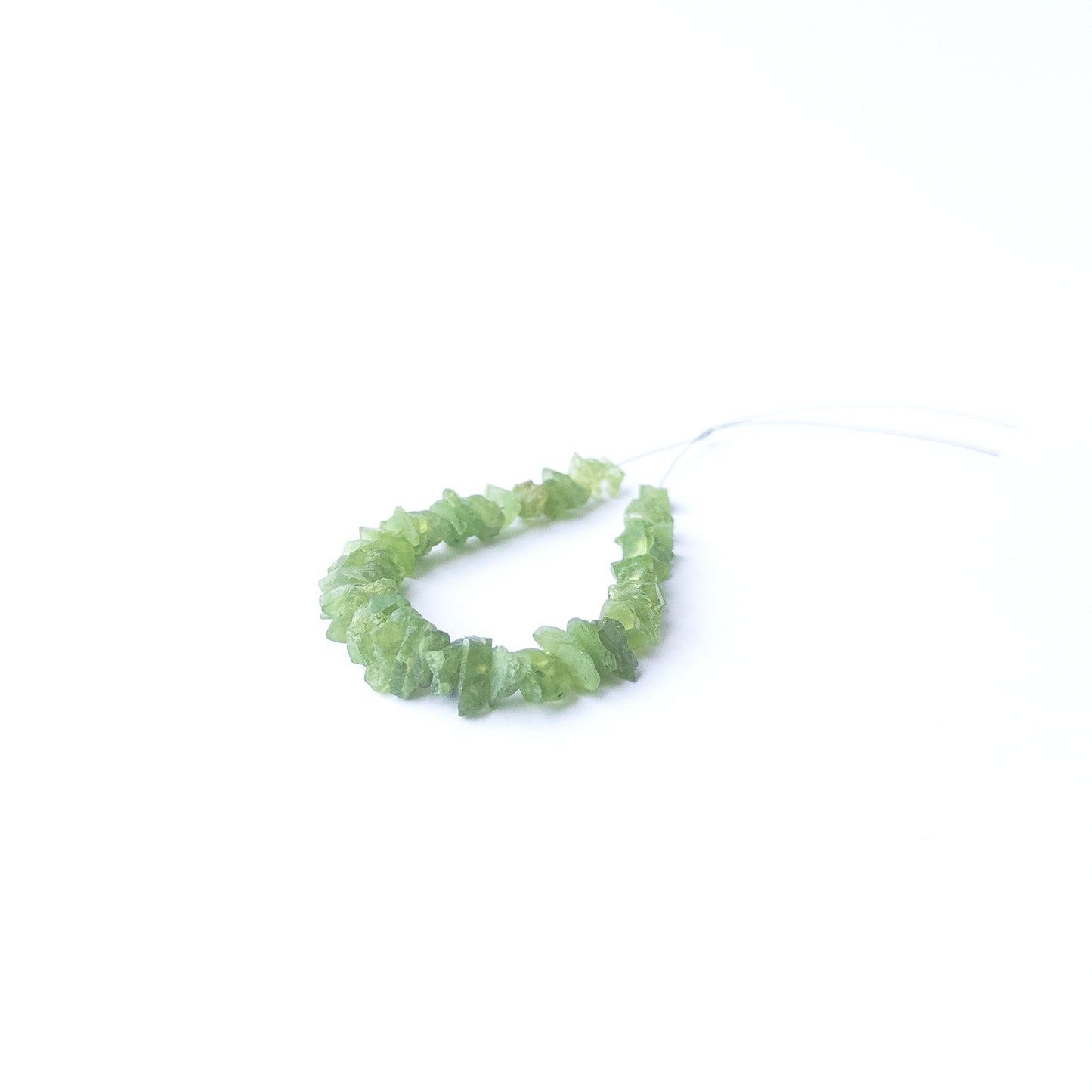 Authentic Peridot rough stone beads arranged to highlight their earthy tone and organic crystal texture.