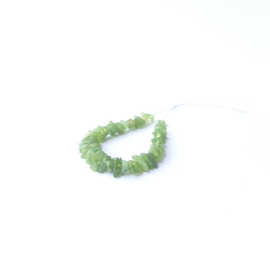 Authentic Peridot rough stone beads arranged to highlight their earthy tone and organic crystal texture.