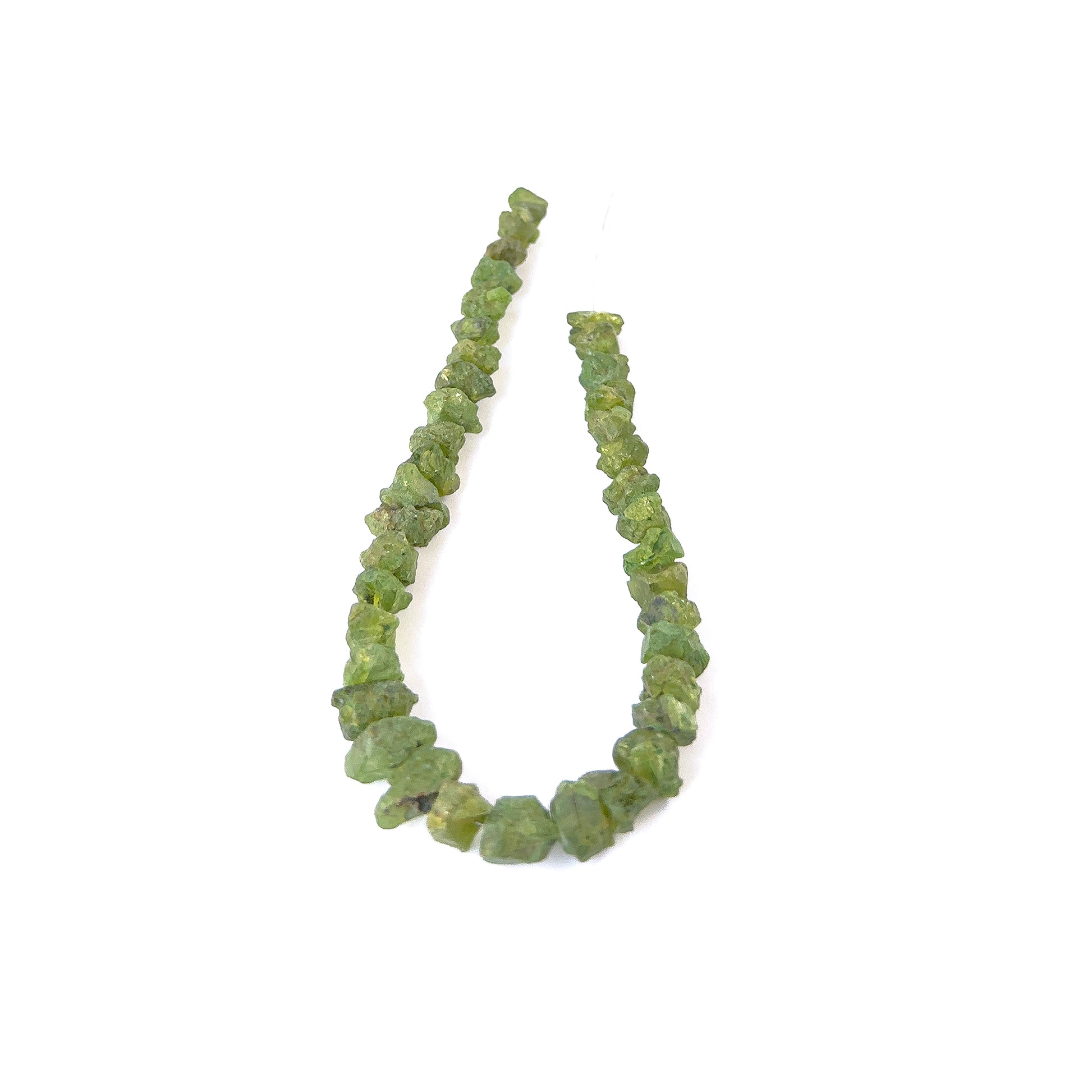 Peridot drilled rough gemstone pieces in bright green tones arranged on a strand for handmade jewellery components.