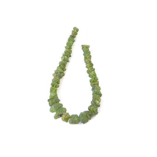 Peridot drilled rough gemstone pieces in bright green tones arranged on a strand for handmade jewellery components.