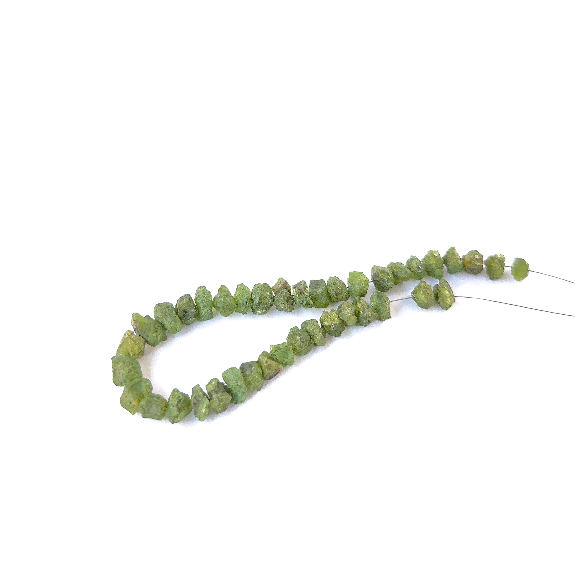 Close‑up of drilled rough Peridot pieces with organic shapes, perfect for authentic gemstone bead jewellery.