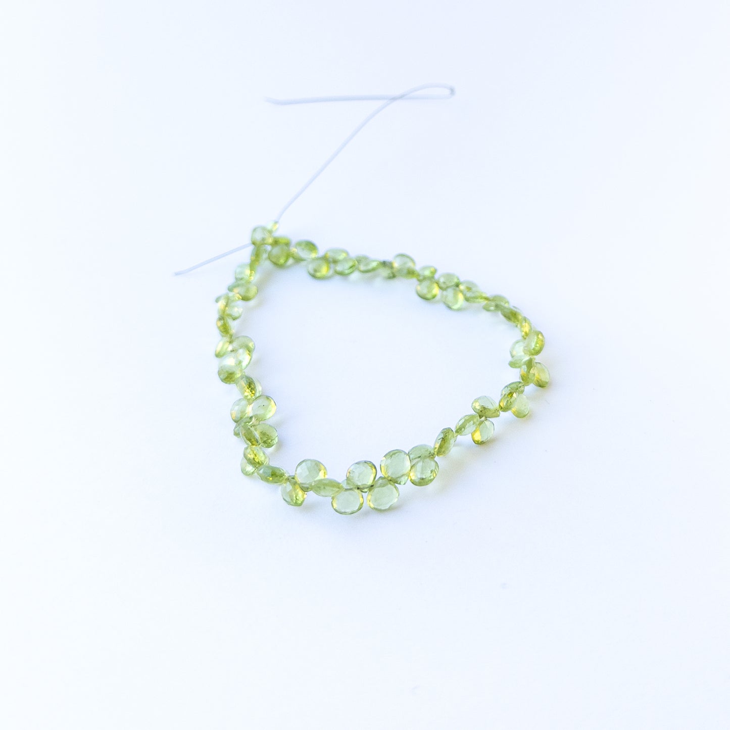 Peridot faceted briolette beads in 5.5–6mm size on a 25cm strand, showcasing genuine gemstone sparkle.