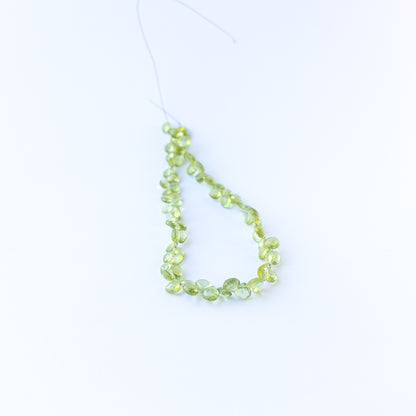 Authentic peridot gemstone beads with polished faceted briolette cuts, ideal for handmade jewellery components.