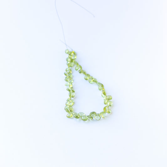 Authentic peridot gemstone beads with polished faceted briolette cuts, ideal for handmade jewellery components.
