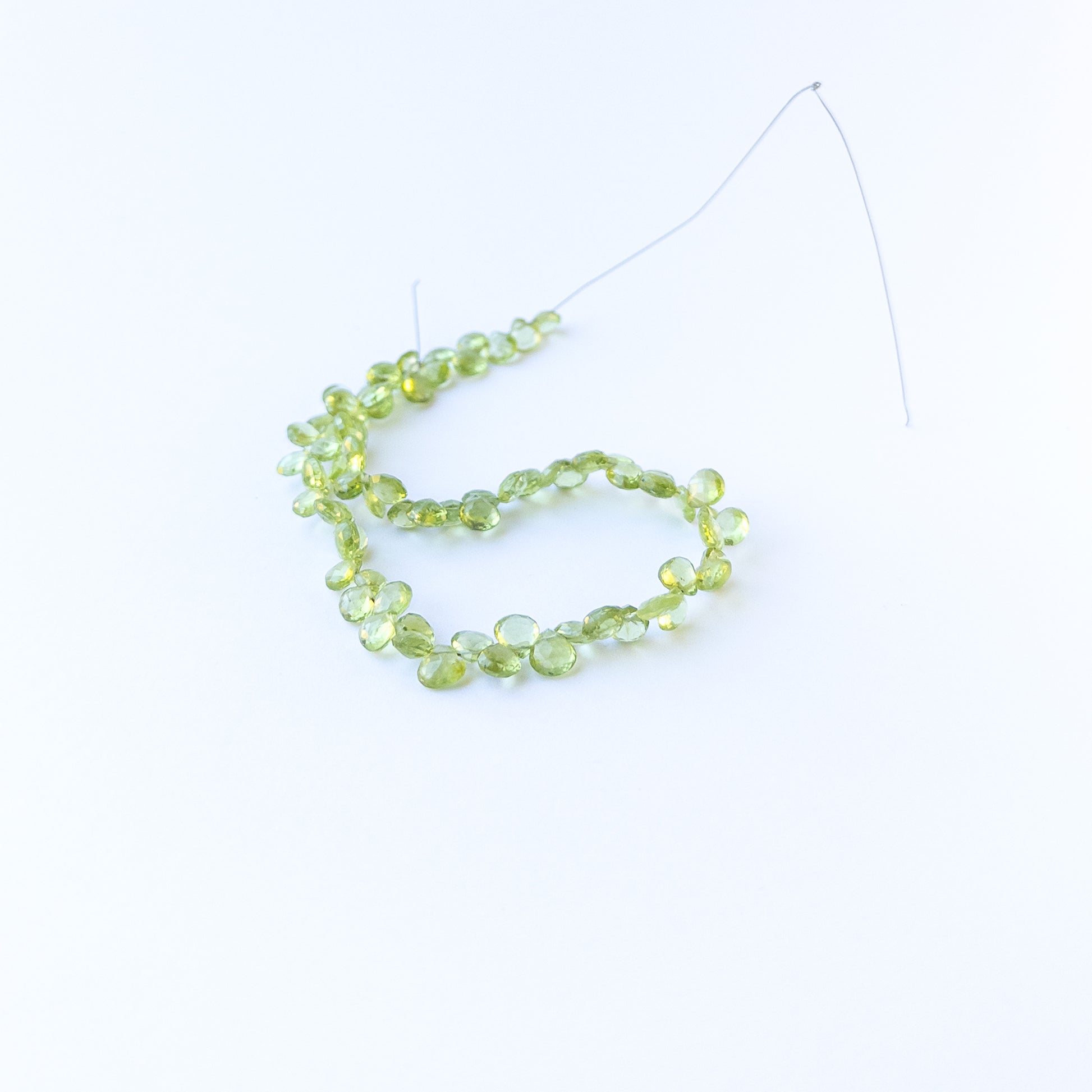 Genuine stone beads in bright green hues, featuring faceted briolettes for DIY jewellery making.