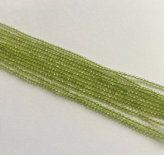 Peridot faceted rondelle beads in 1.9–2.2mm sizes, strung neatly on a 32cm strand with a brilliant green hue.