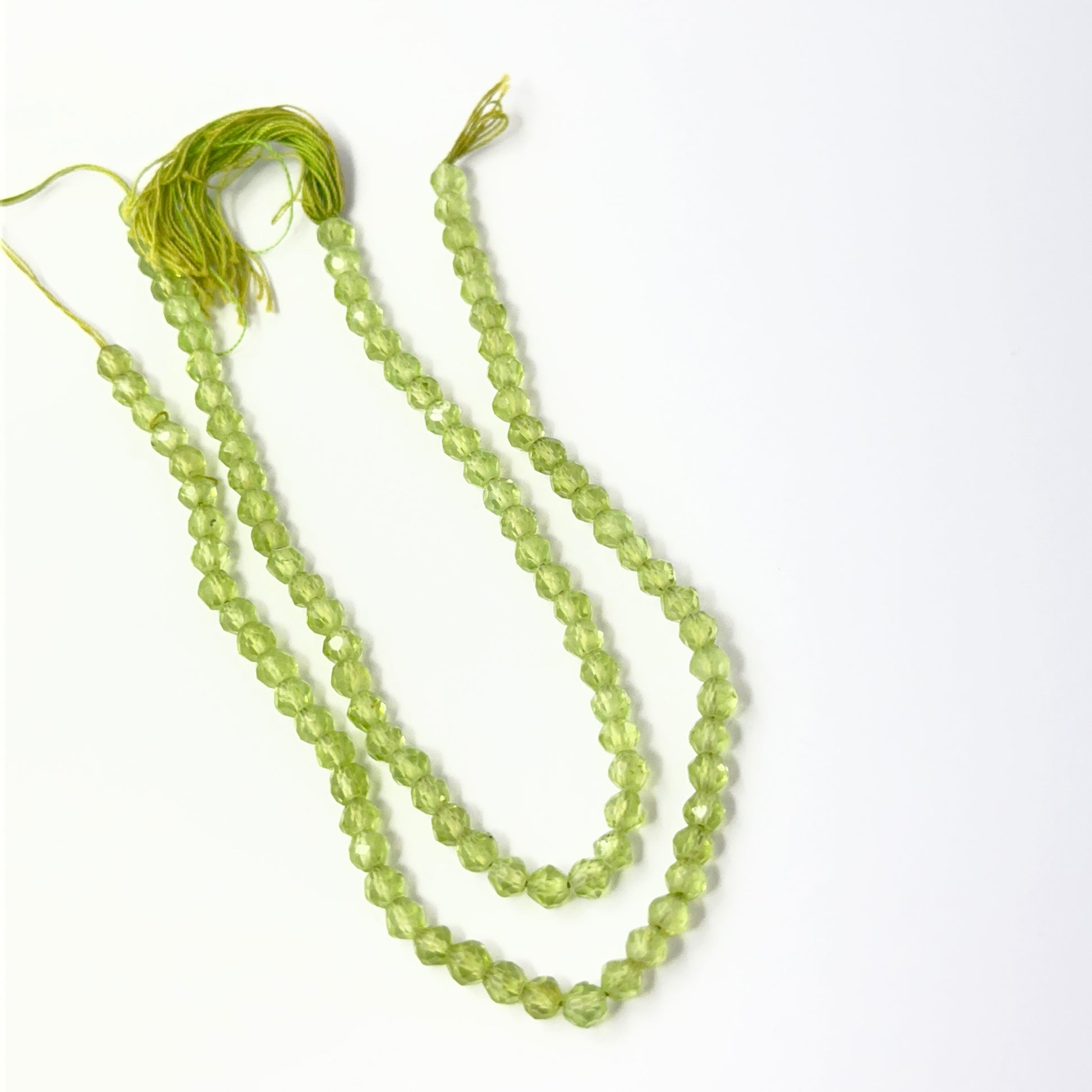 Peridot faceted rondelle beads in bright green tones, showcasing 3.4mm stone beads ideal for DIY jewellery.
