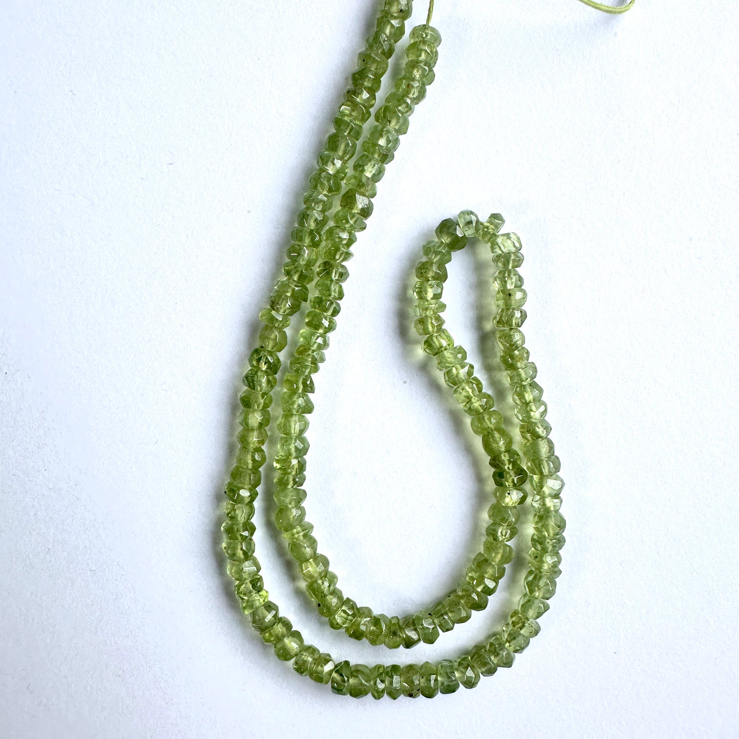 Close-up of Peridot beads showcasing their brilliant sparkle and detailed cut.