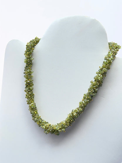 Close‑up of polished peridot chips arranged on a finished peridot necklace.