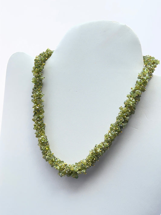 Close‑up of polished peridot chips arranged on a finished peridot necklace.