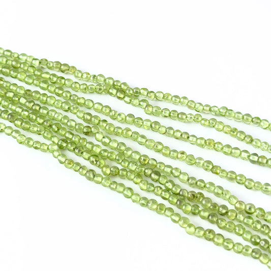 Smooth round Peridot stone beads arranged neatly, highlighting their polished finish and handmade jewellery component quality.