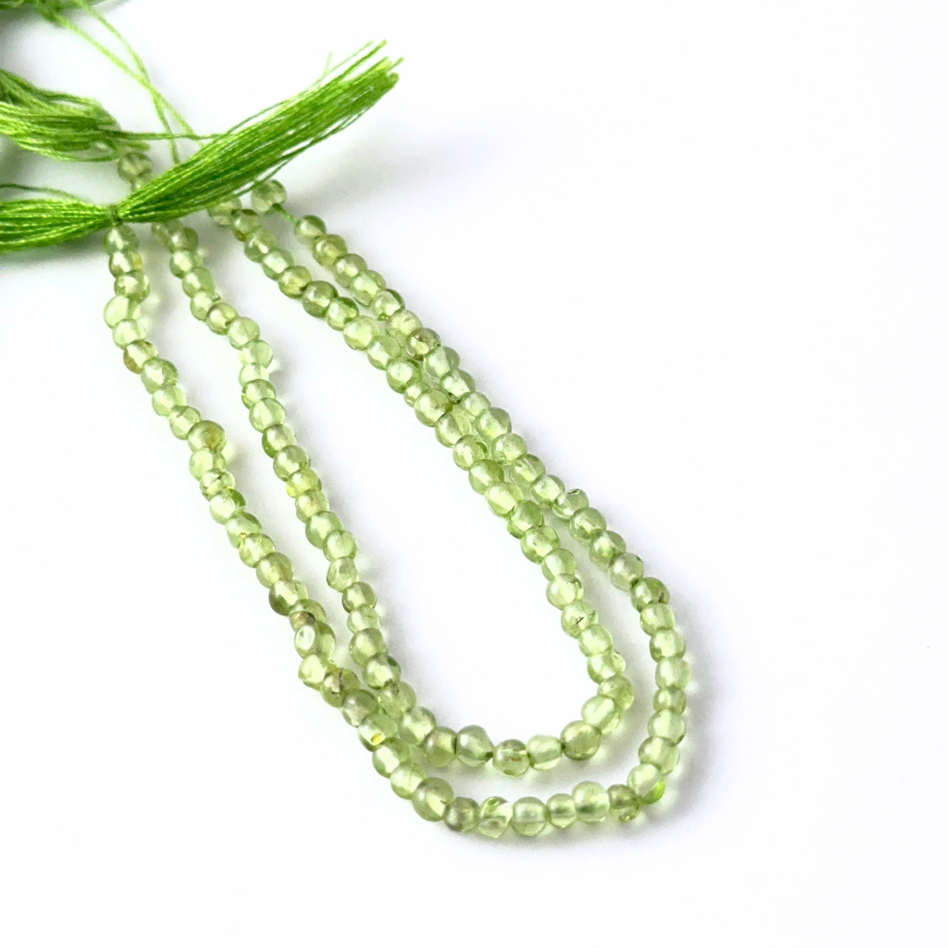Peridot round beads with natural bright green hues and gentle lustre, ideal for authentic stone beads in creative jewellery designs.