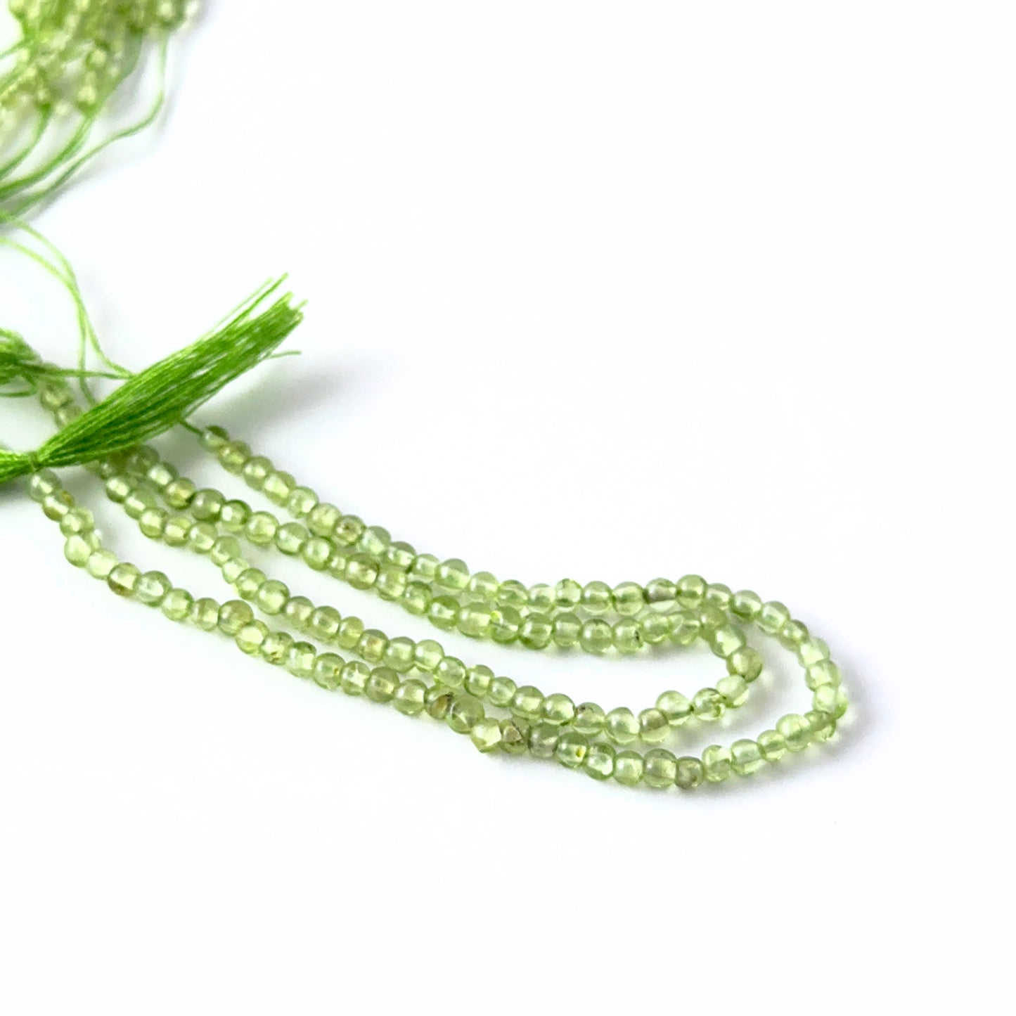 Close view of Peridot smooth round beads showing clarity, colour and premium gemstone quality for jewellery makers.