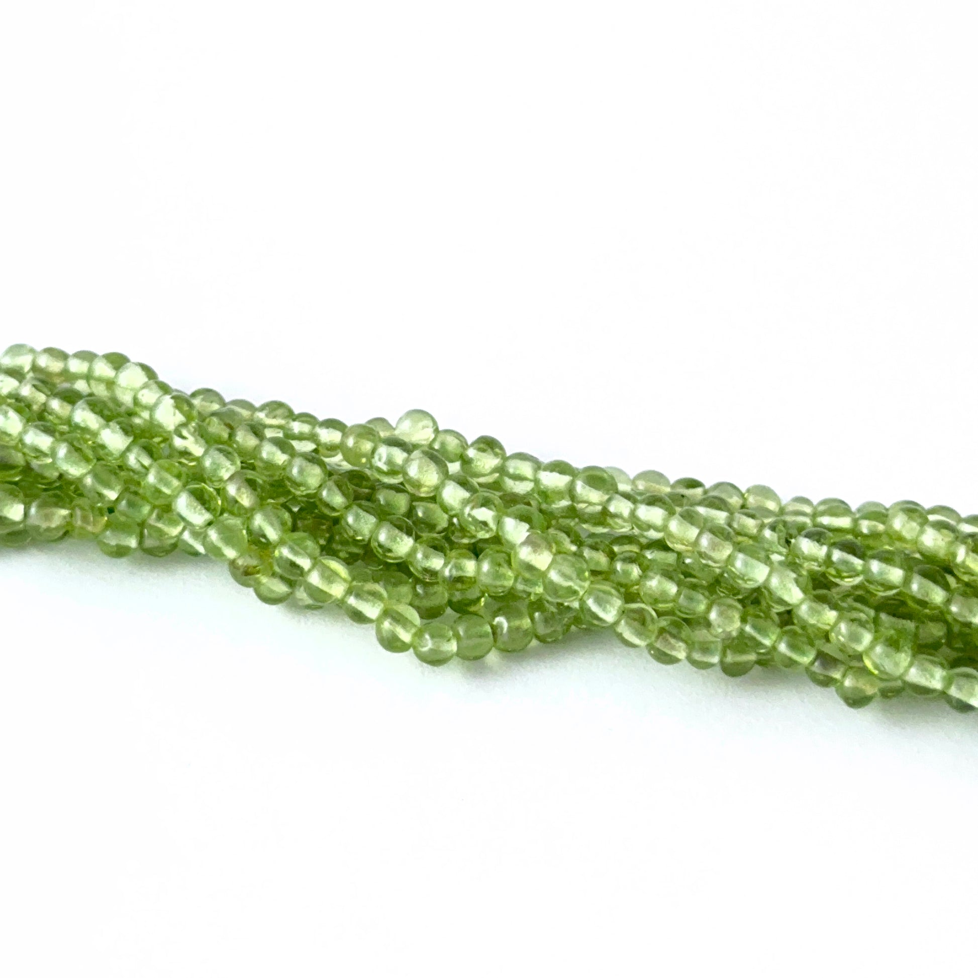 Peridot smooth round gemstone beads showing fresh green tones and shine for genuine gemstone beads in DIY jewellery.