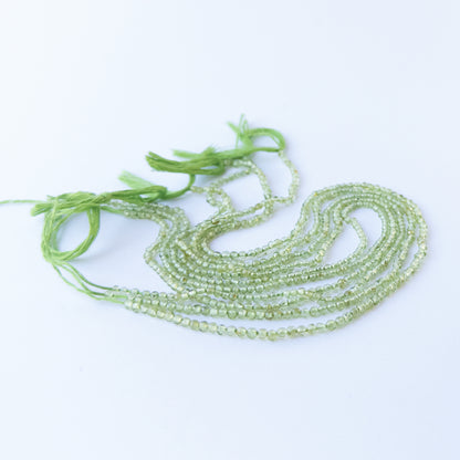 Genuine Peridot gemstone beads arranged on a 32cm strand, showcasing clarity and soft glow.