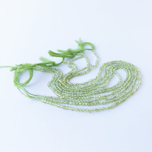 Genuine Peridot gemstone beads arranged on a 32cm strand, showcasing clarity and soft glow.