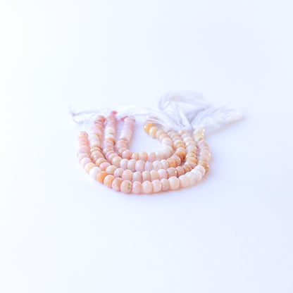 Peruvian Opal faceted rondelles arranged neatly, highlighting their polished finish and gentle colours.
