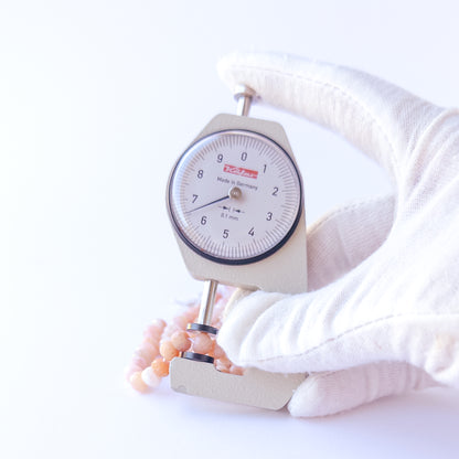 A dial gauge measures the Peruvian Opal faceted rondelle 6.5mm gemstone.