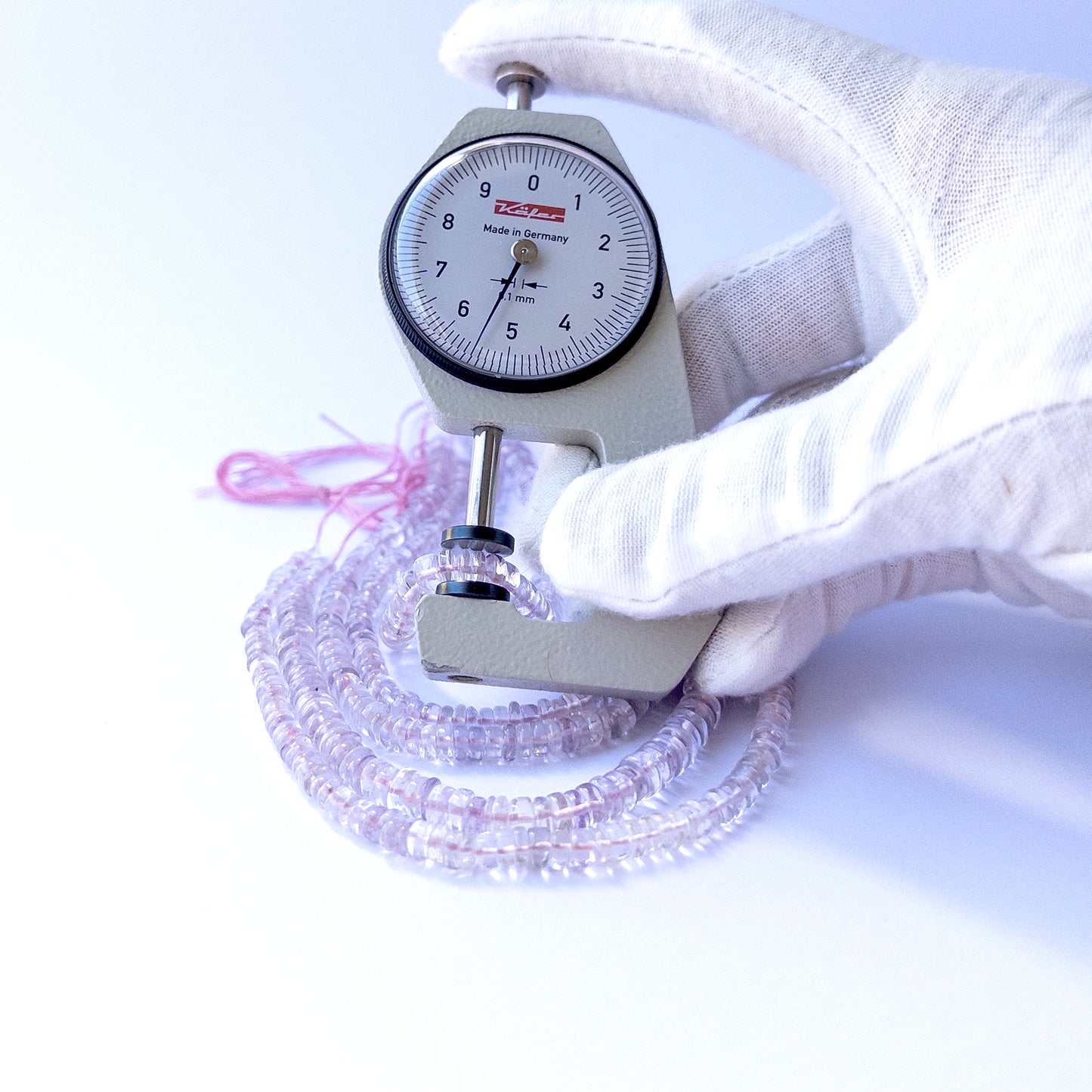 A dial gauge measures the Pink Amethyst smooth wheel 4.3–6mm gemstone.