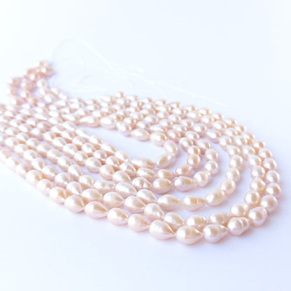 Authentic pink freshwater pearls, 7.5–8mm baroque oval beads offering natural lustre and organic charm.