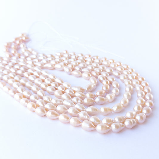 Authentic pink freshwater pearls, 7.5–8mm baroque oval beads offering natural lustre and organic charm.