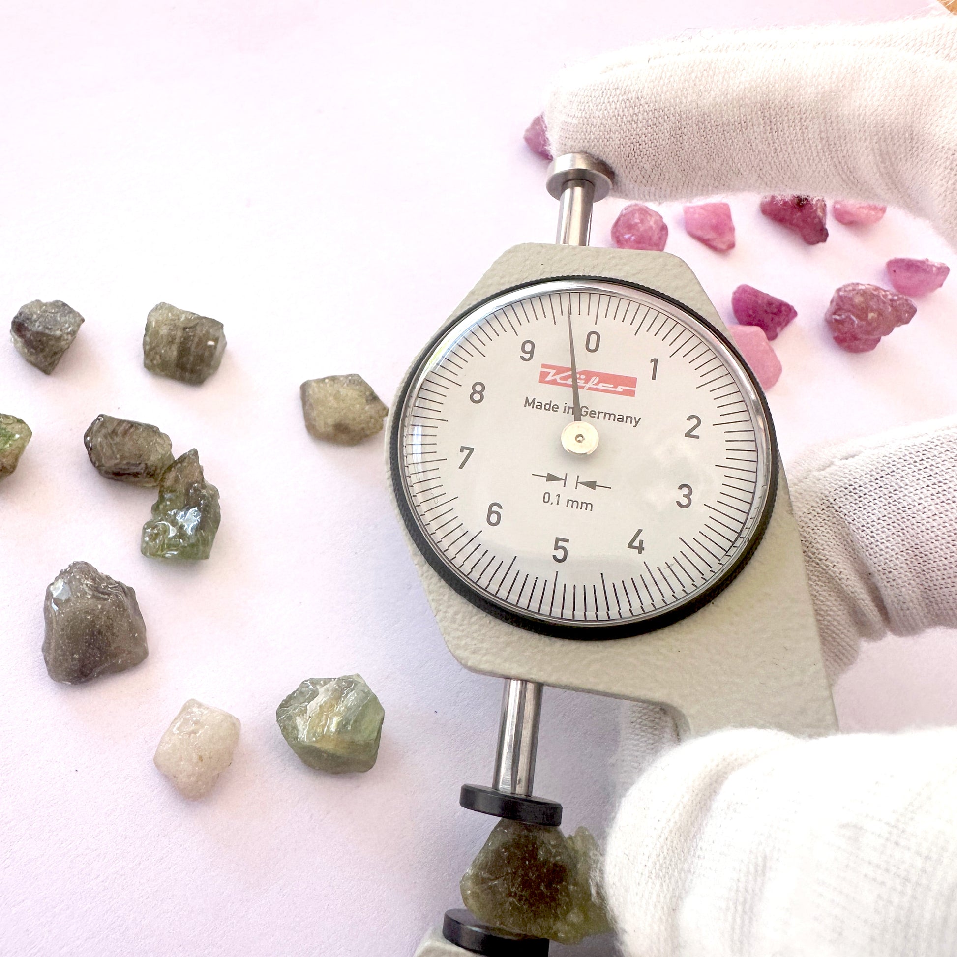 A dial gauge measures the sapphire rough cut 8–11mm gemstone.