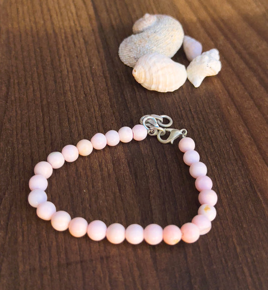 Delicate strands of  pink opal beads, showcasing their smooth design.