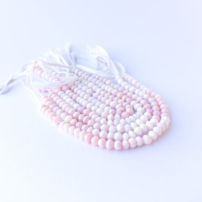 Premium pink opal gemstone beads for DIY jewellery, displaying faceted rondelle cuts and delicate pink hues.