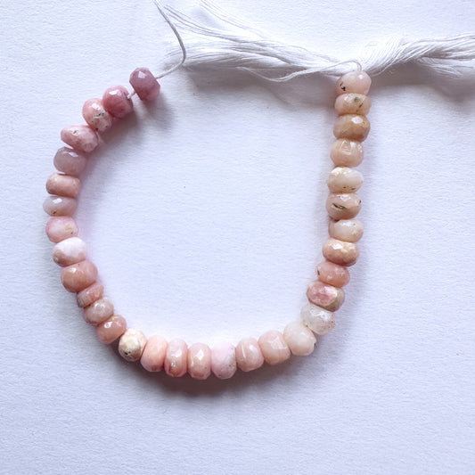 Natural gemstone beads with soft pink hues and sparkling facets, arranged on a 14cm strand.