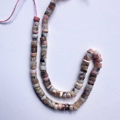 Close-up of Pink Opal beads showcasing their gentle colour and sleek disc shape.