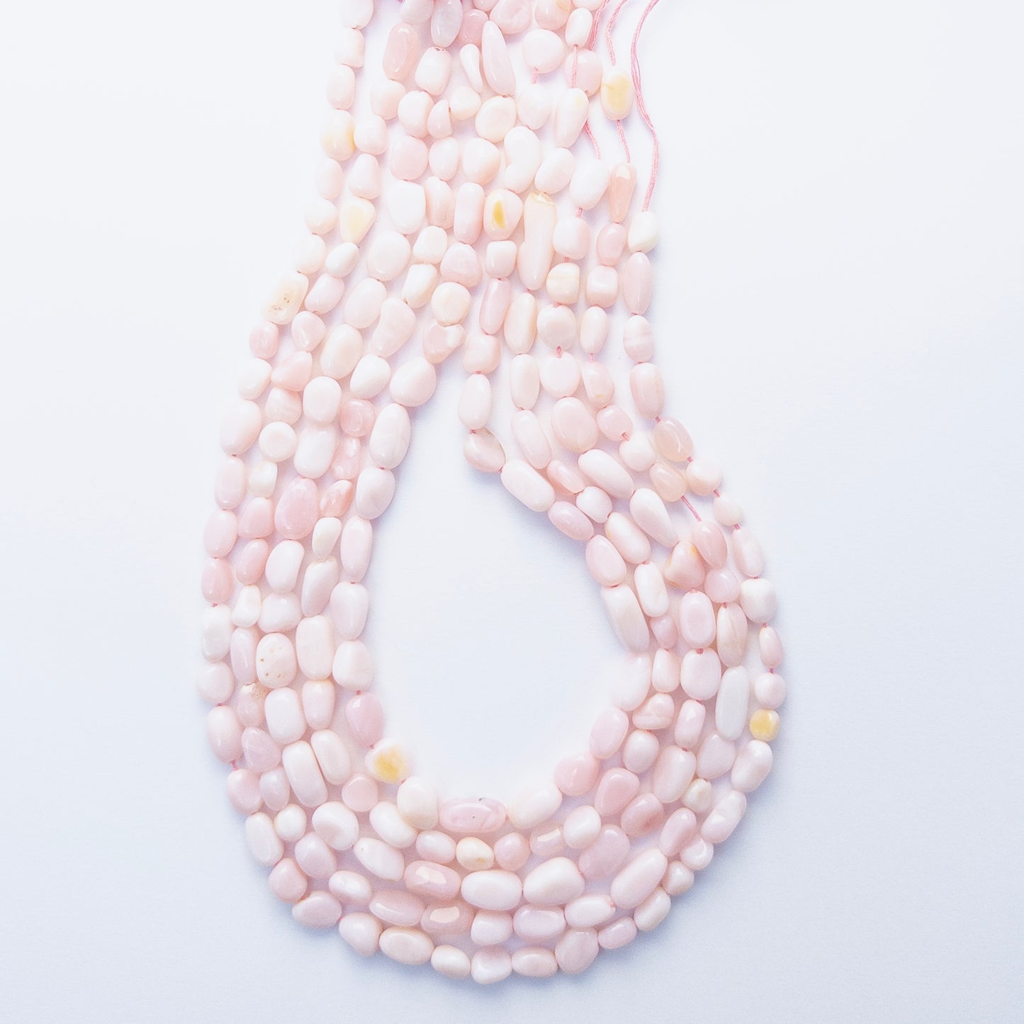Close‑up of Pink Opal tumble gemstone beads highlighting their warm blush hues and smooth finish.