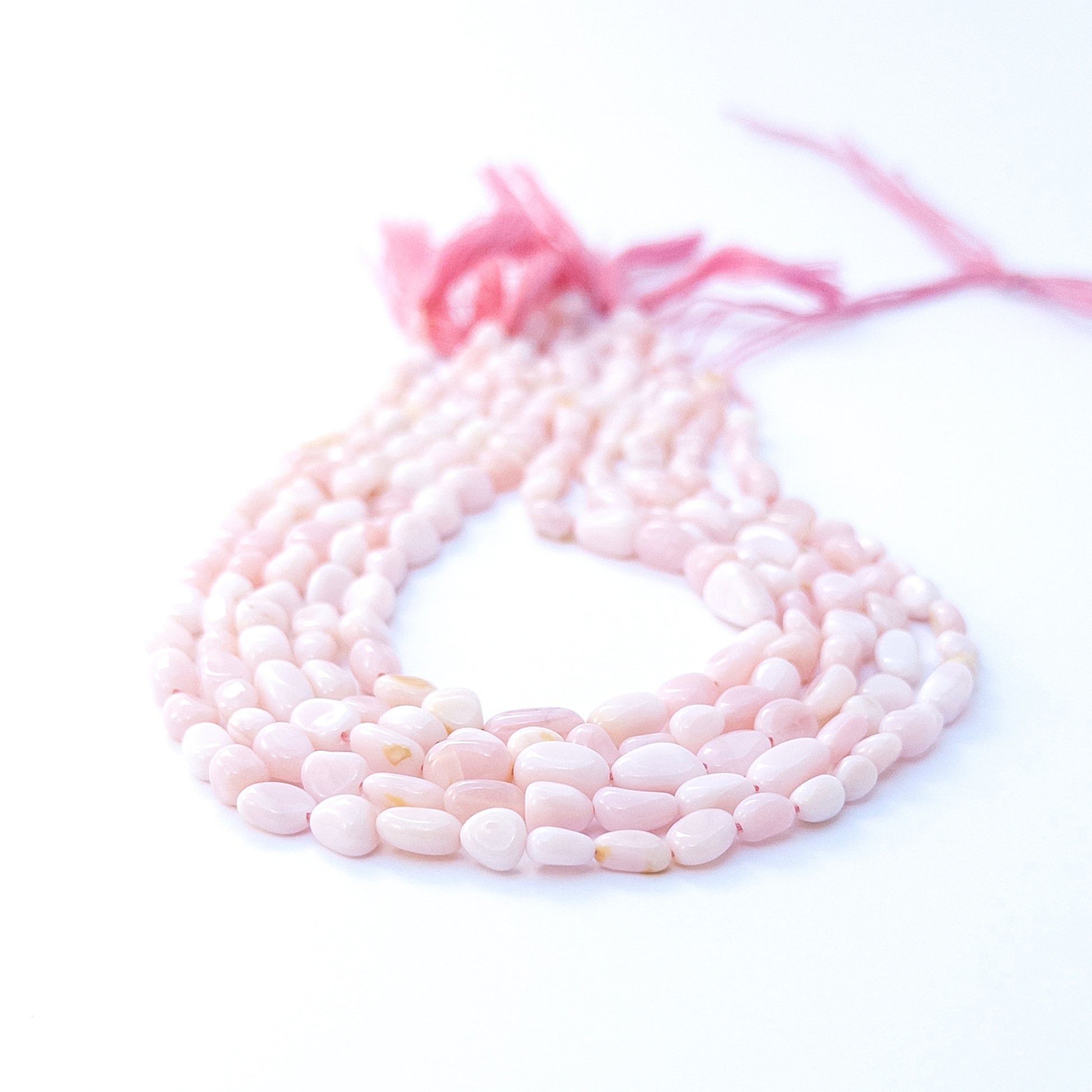 Handmade jewellery components featuring Pink Opal tumble beads with subtle shine and natural charm.