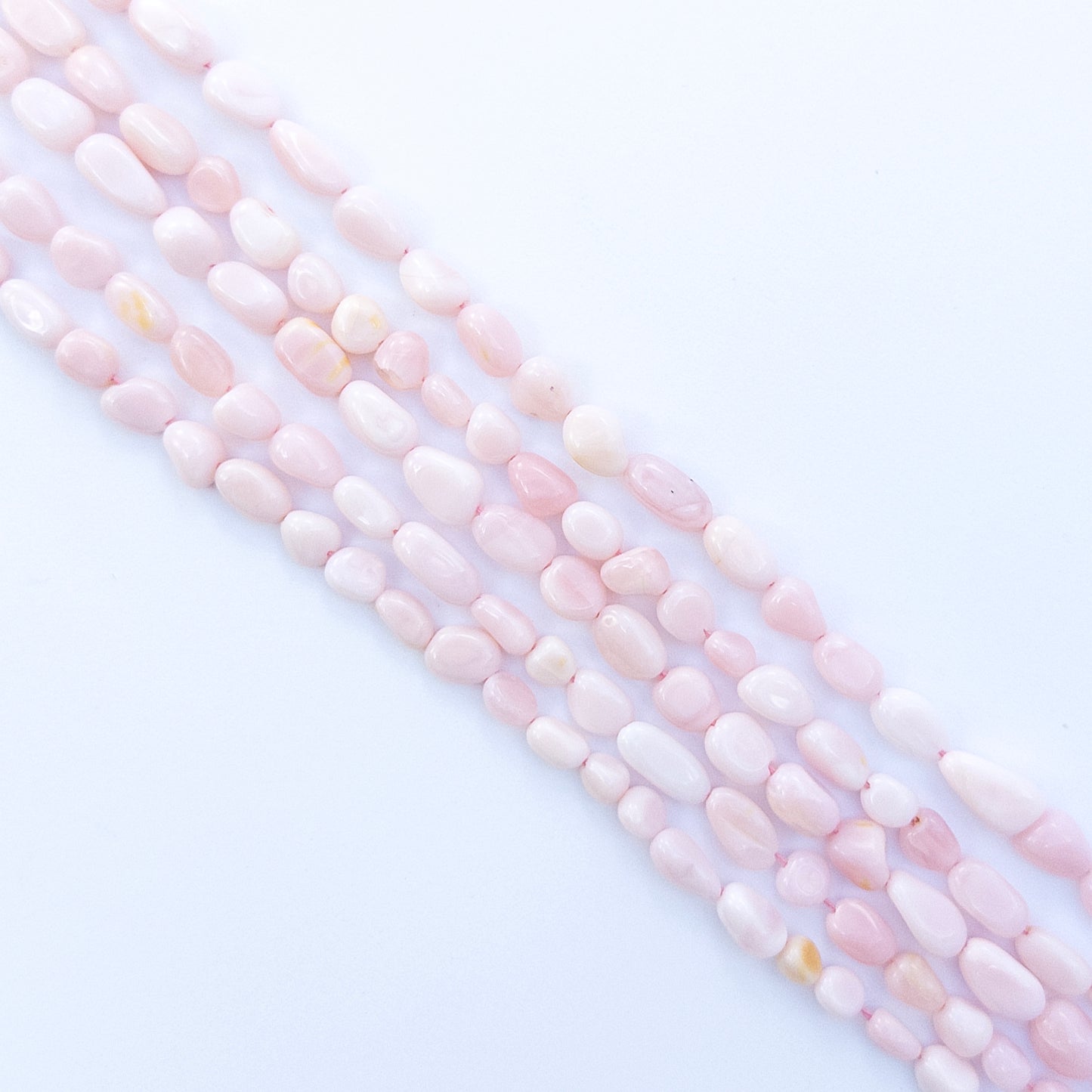 Pink Opal smooth tumble 4–5mm gemstone, showcasing their smooth tumble design and sparkle.




