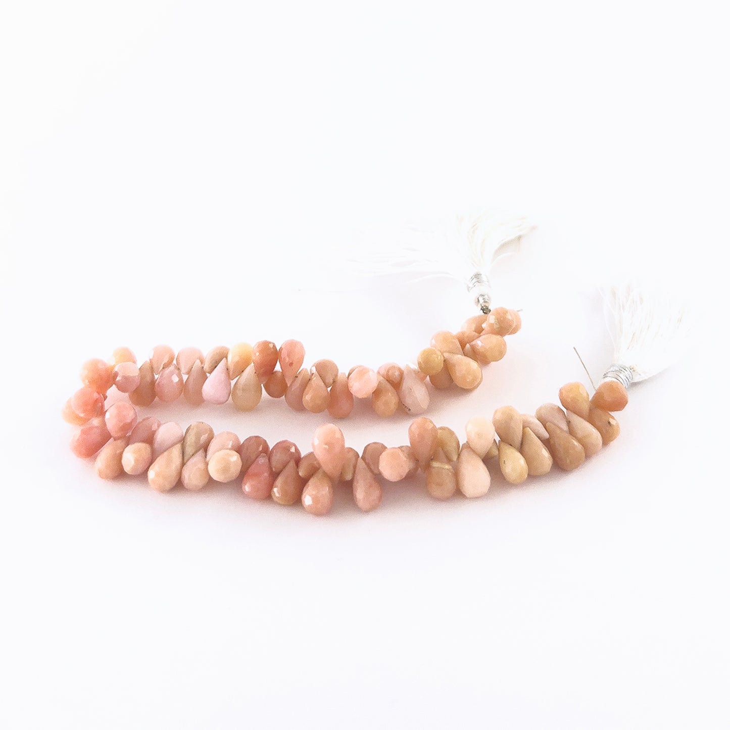 Pink Peruvian Opal briolette beads featuring crisp faceting and gentle rosy hues in consistent 6–6.5mm sizing.
