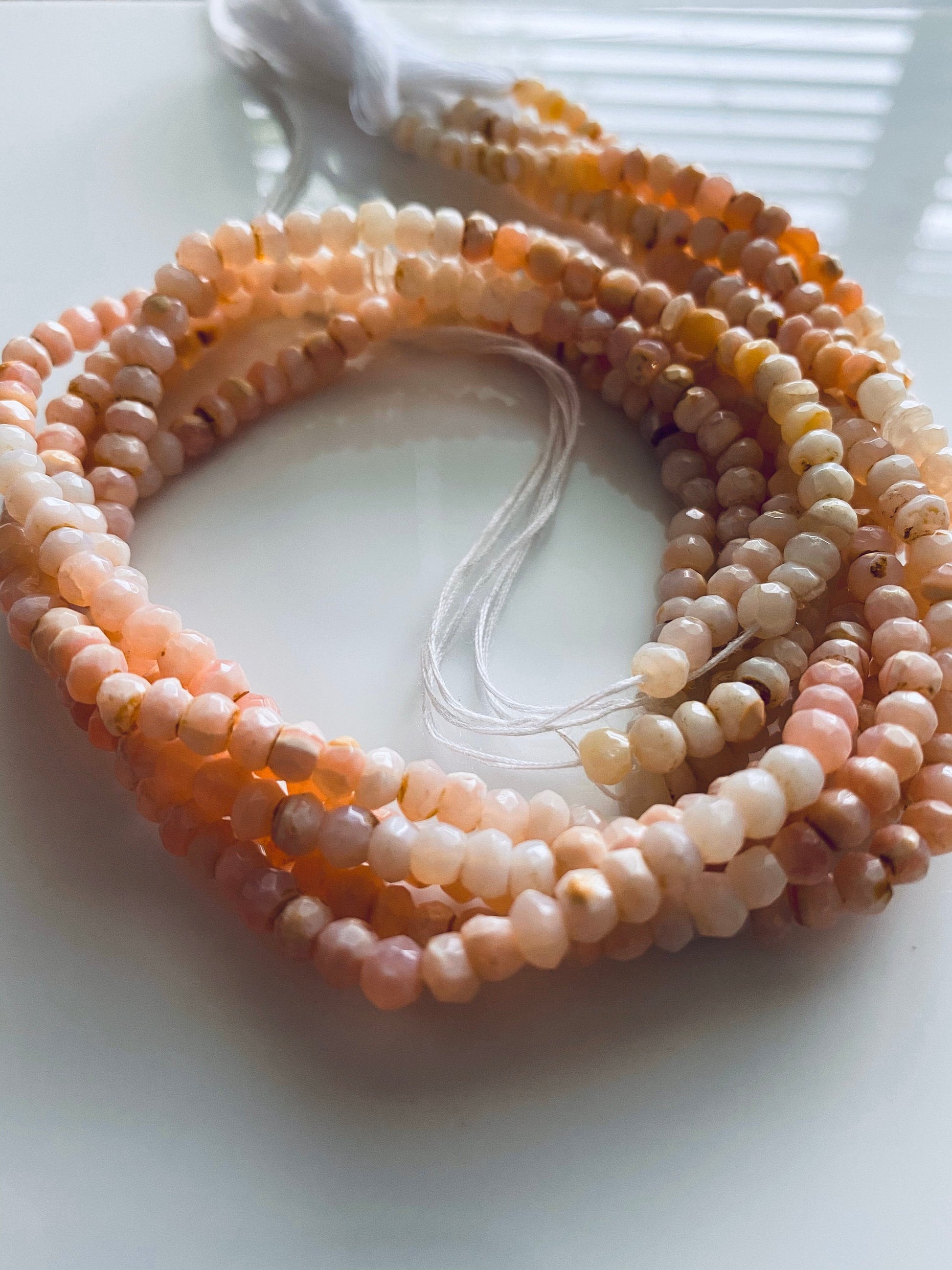 Close-up of 4.4mm to 4.7mm Pink Peruvian Opal beads, showcasing delicate faceted detailing.
