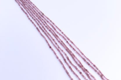 Stone beads in Strawberry Quartz finish laid flat to highlight their 2.5mm size and faceting.