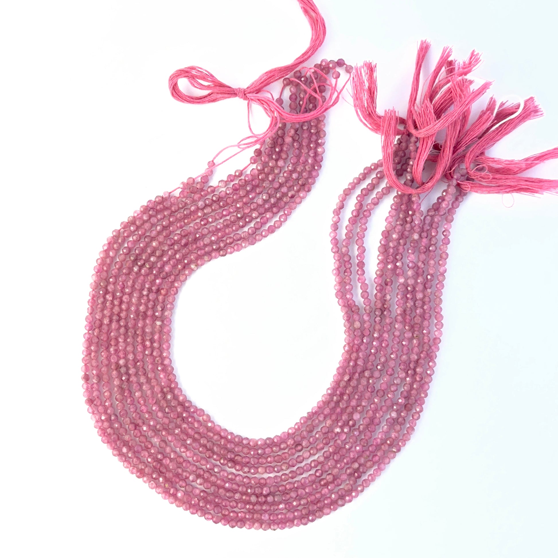 Faceted rondelle Pink Tourmaline beads arranged neatly, highlighting their polished finish and handmade jewellery component quality.