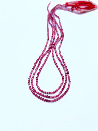 Pink Tourmaline 2.2mm faceted rondelle beads arranged on a strand, showing crisp faceting and vivid pink tones.