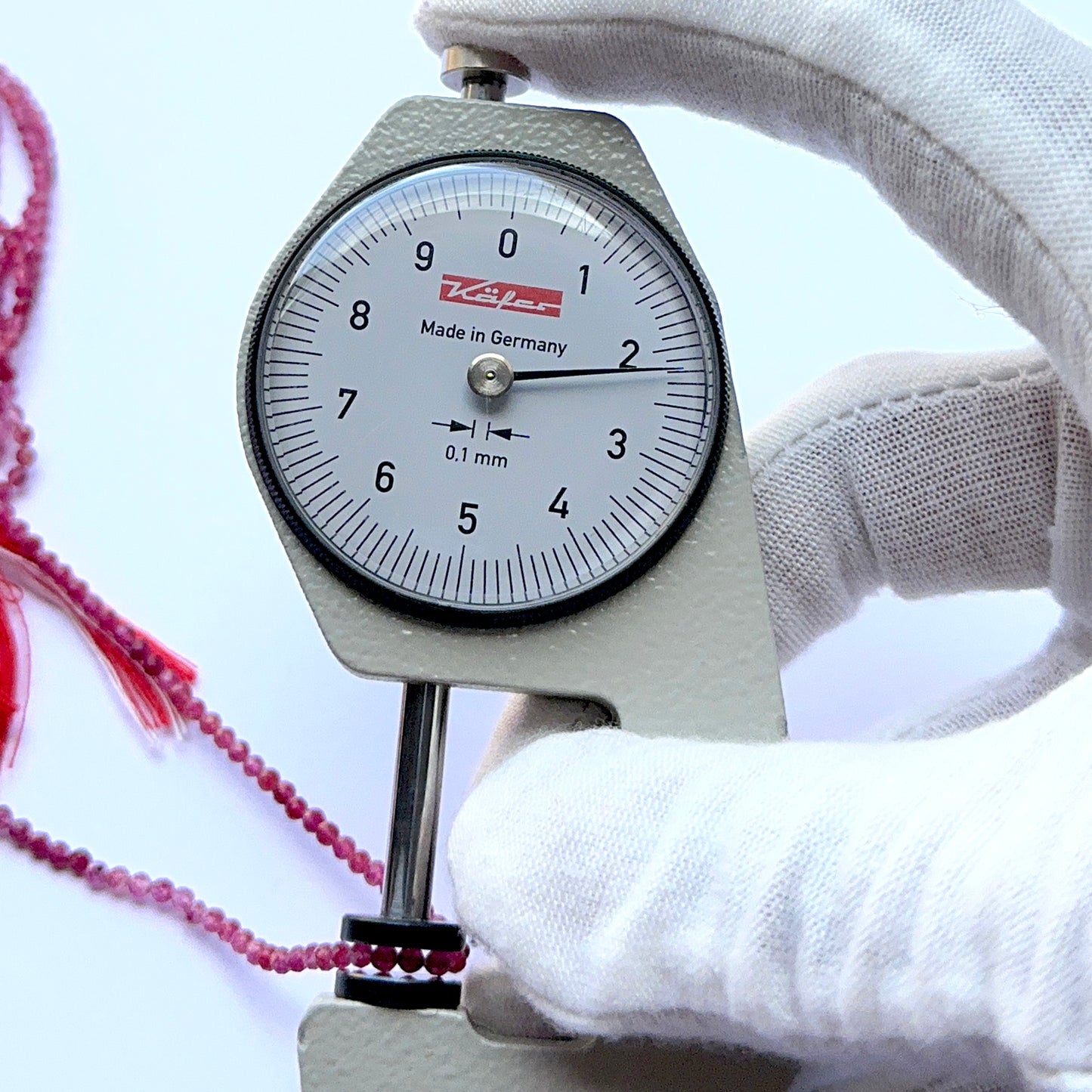 A dial gauge measures the Pink Tourmaline faceted rondelle 2.2mm gemstone.