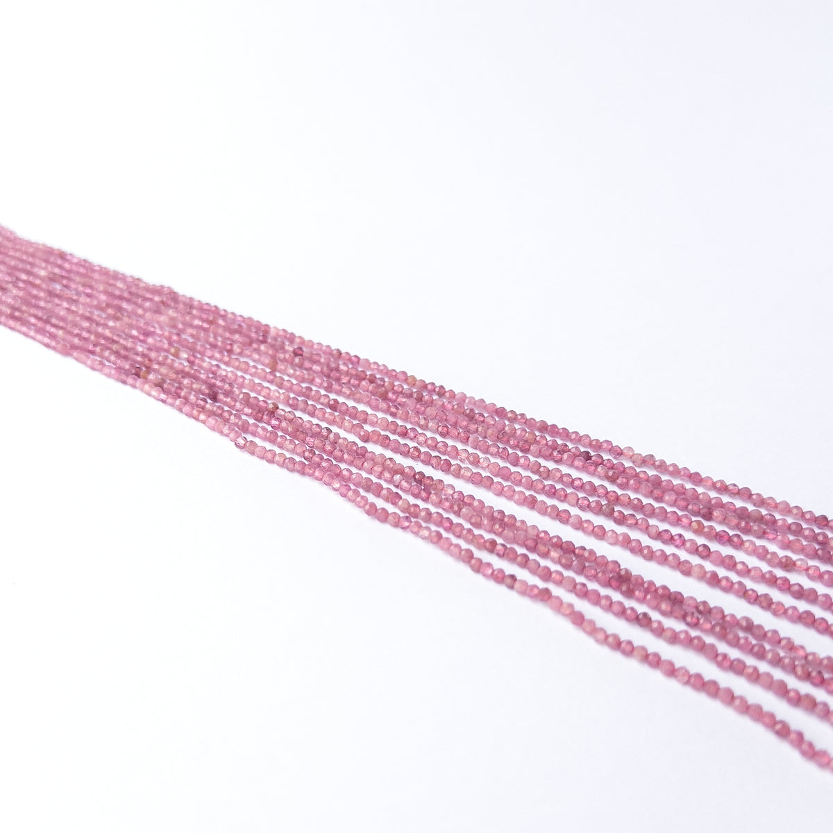 Close‑up of Pink Tourmaline faceted rondelle beads revealing shine, cut and craftsmanship.