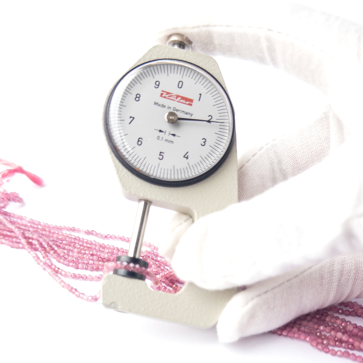 A dial gauge measures the Pink Tourmaline faceted rondelle 2.2mm gemstone.  