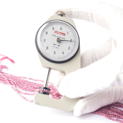 A dial gauge measures the Pink Tourmaline faceted rondelle 2.2mm gemstone.  